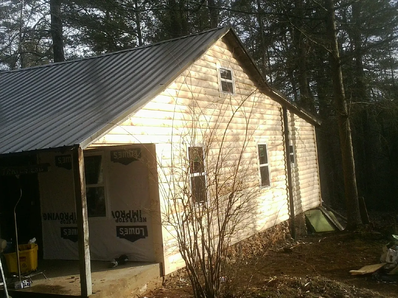 Log siding gable end under a dark metal roof edge in Maryland Heights