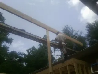 Carpenter setting a ridge beam over a new addition frame — Ice Dam Removal by Roofing Brothers in Maryland Heights