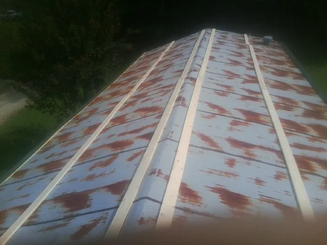 Rusted metal roof panels with new wood purlins before replacement — Storm Damage Roof Repair in Maryland Heights by Roofing Brothers