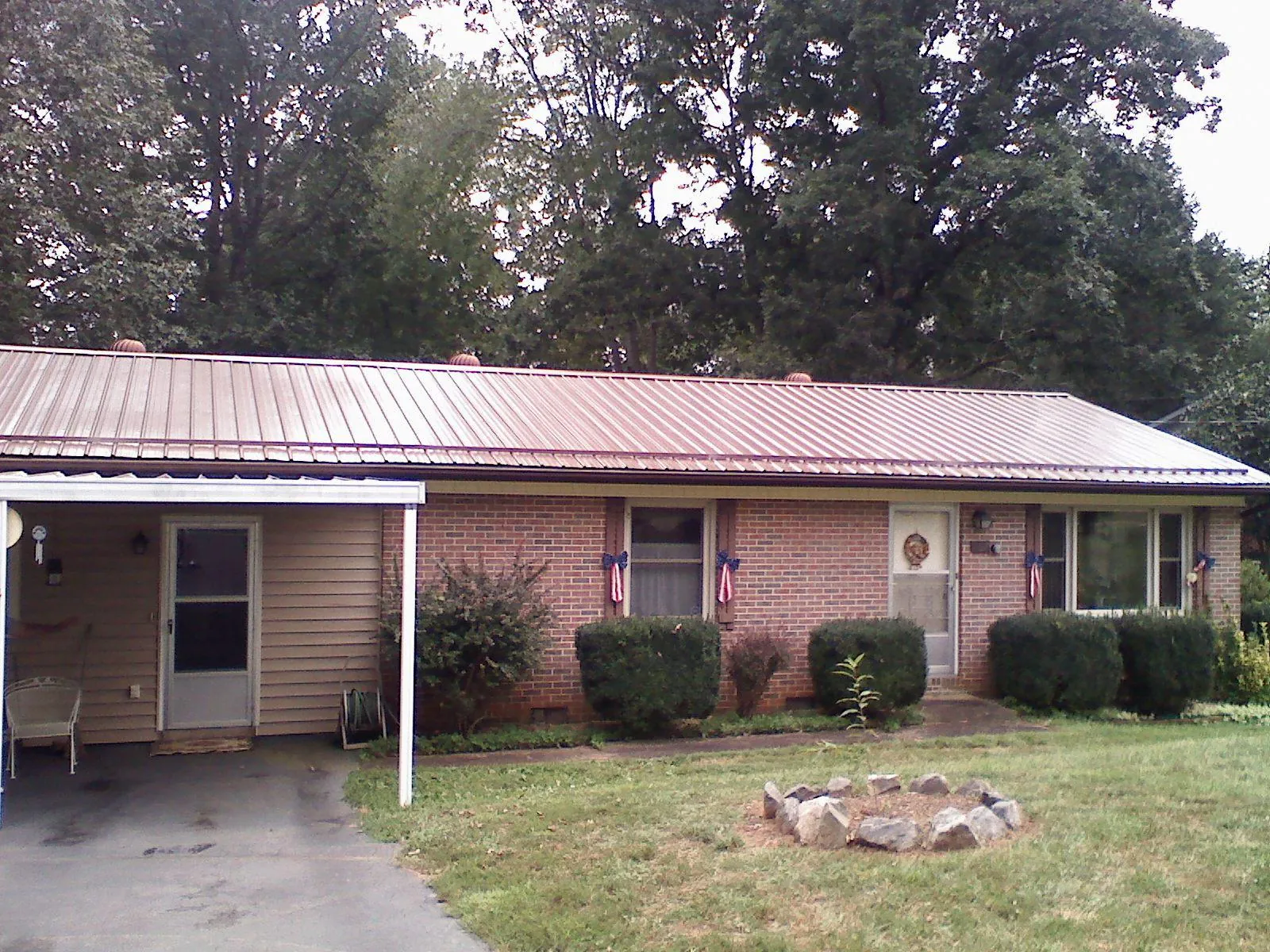 Bronze metal roof and carport on a brick ranch home — Roof Repair work by our crew in Maryland Heights